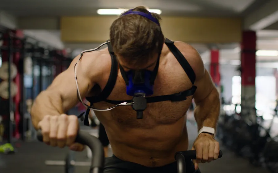 An athlete mid-movement wearing a metabolic analysis harness.